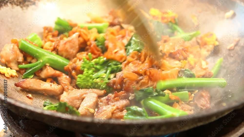 Man frying noodles with pork and vegetable in pan , Thai famous food Man frying noodles with pork and vegetable in pan , Thai famous food