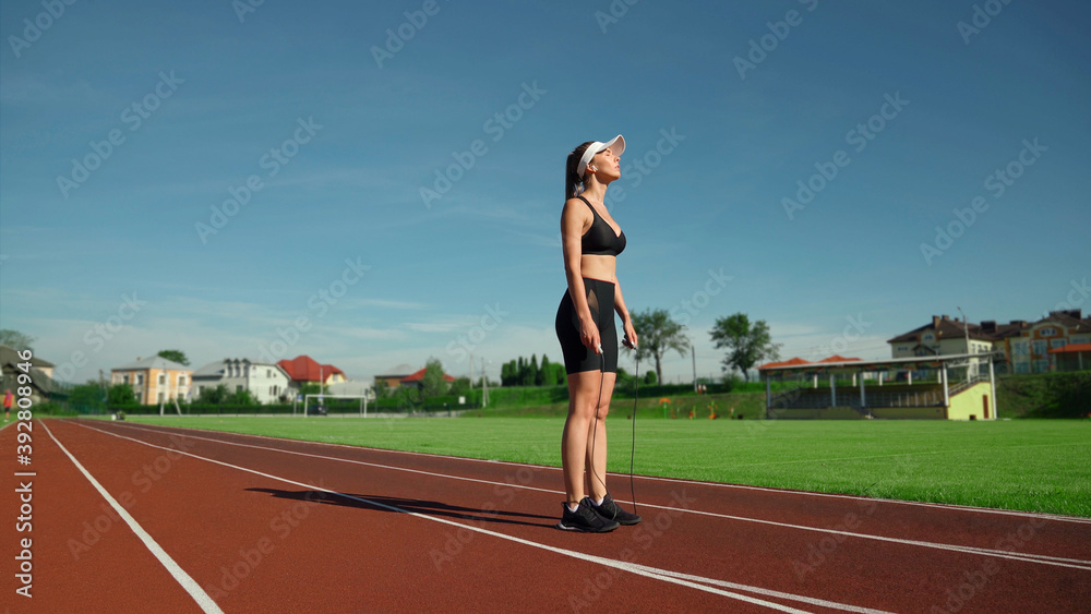 Athlete woman holding skipping rope outdoors.