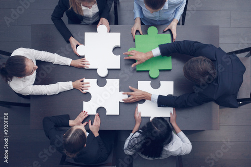 Business people assembling puzzle