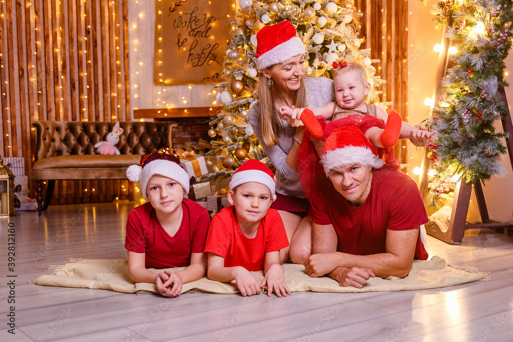 Beautiful happy family of five at a Christmas photo shoot in a studio in gold style. people for Christmas. Beautiful happy family of five at a Christmas photo shoot in a studio in gold style. people for Christmas.