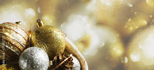 Christmas background with luxury  golden decoration. New Year's decor. Shiny Christmas balls and glowing garlands in a basket on a golden bokeh lights background.. photo