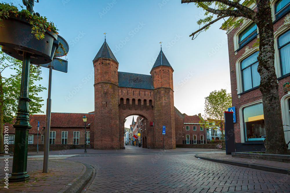 Old city gate Kamperbinnenpoort in Amersfoort city. Two towers are connected to an arch gate.