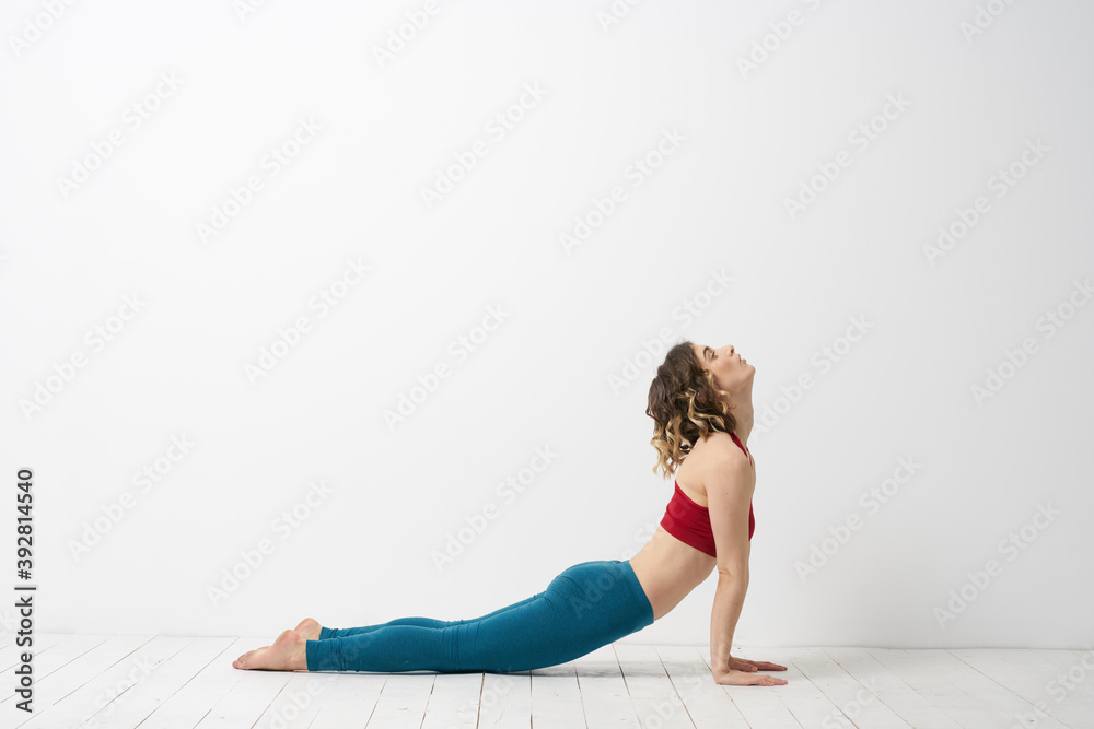 Fototapeta premium woman in leggings is engaged in gymnastics in a light room slim figure fitness sport