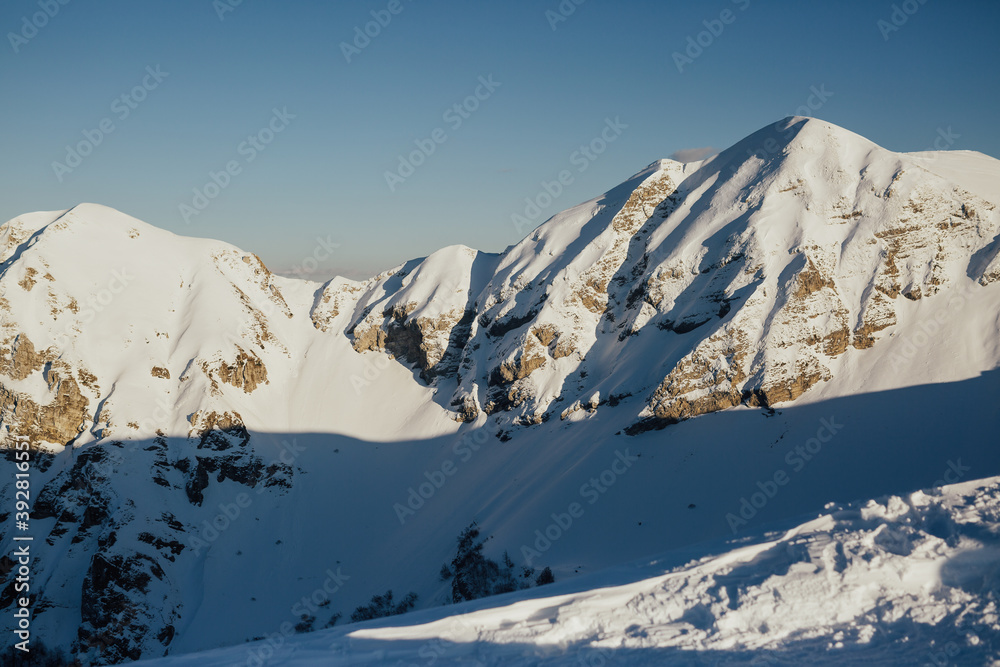 Beautiful view of the rocky European Alps covered with snow in sunny day with blue sky on the background. Copy space. 
