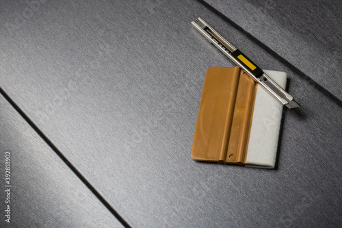 Knife and squeegee close up on wrapped car photo