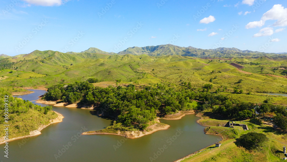 Landscape with green hills and meadows under a blue sky, view from above. Bohol, Philippines.