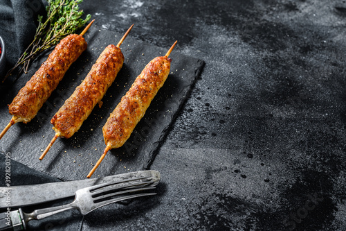 Lula kebab. Shish kebab on a stick, from ground beef meat. Black background. Top view. Copy space