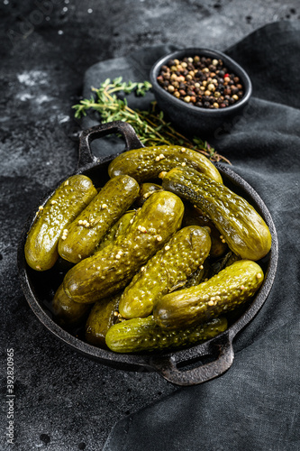 Plate of pickled homemade cucumbers, pickles. Black background. Top view