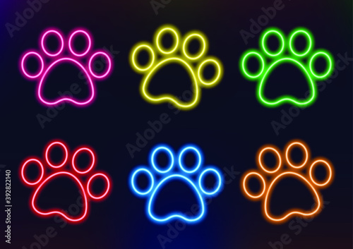 Neon frame. Set of neon animal paws in different colors. Laser glowing lines on a dark background. photo