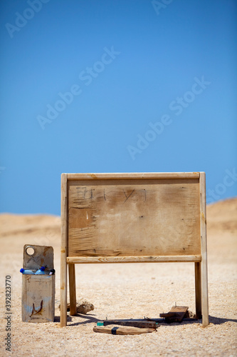 An old blank empty wooden sign in the middle of the desert.