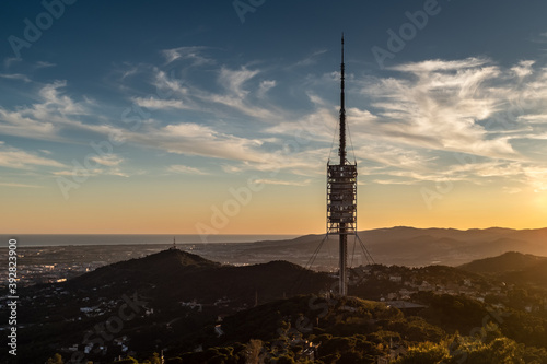 Barcelona (Catalonia, Spain) and its surrounding. The telecommunications tower and the hilly landscape at sunset. Shot was taken from from the Mount Tibidabo.
