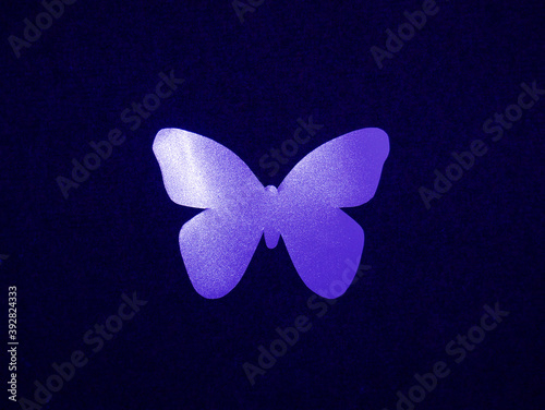 Butterfly light purple with a glitter of paper on a dark background.