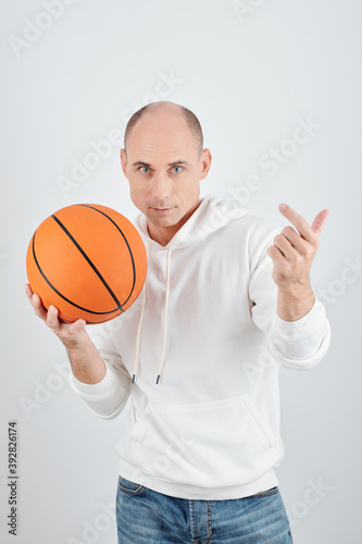 Studio portrait of seroius mature man inviting you to play basketball