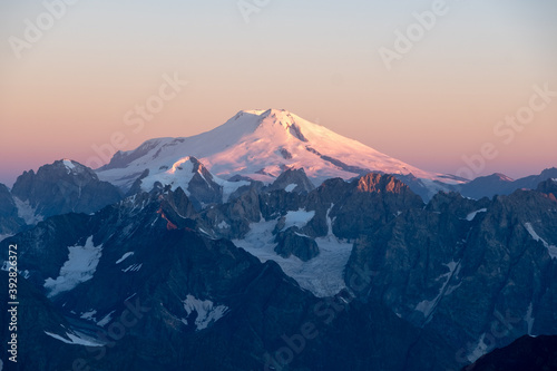 Mount Elbrus, the highest mountain in Europe and a dormant volcano in the Caucasus Mountains in Russia. The first rays of the sun illuminate Elbrus summit at the sunrise, August 2018.