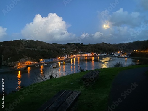 Moon light reflecting over the sea in a peaceful harbour at twilight