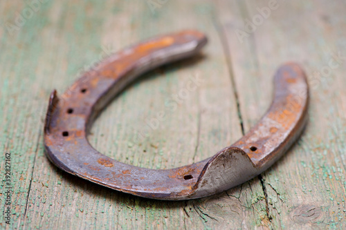 old horseshoe laying on wooden plank photo