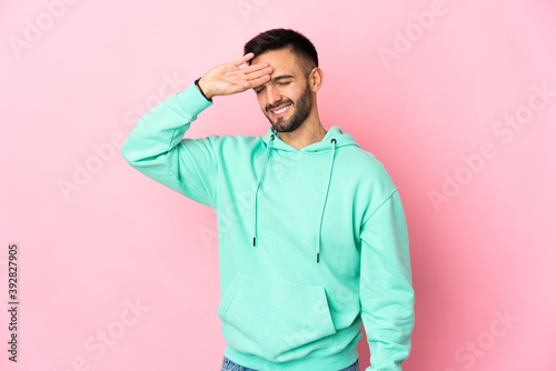 Young caucasian man isolated on pink background with tired and sick expression © luismolinero