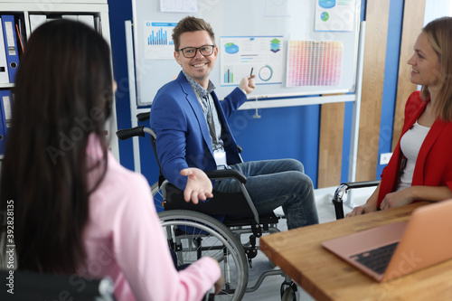 Businessman in wheelchair holds business conference in office. Small and medium business development concept