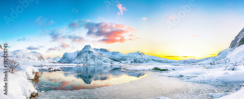 Fantastic frozen Flakstadpollen and Boosen fjords and reflection in water during sunrise with Hustinden mountain on background on Flakstadoya island photo