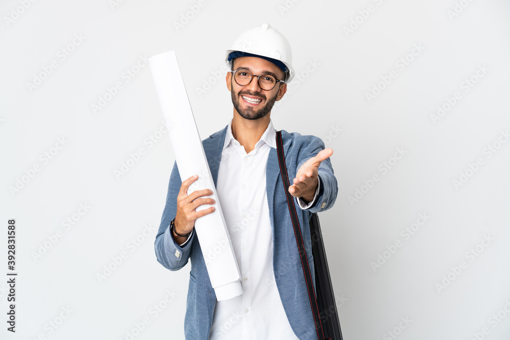 Young architect man with helmet and holding blueprints isolated on white background shaking hands for closing a good deal Young architect man with helmet and holding blueprints isolated on white background shaking hands for closing a good deal