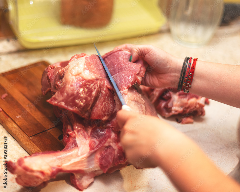 piece of fresh meat leg of pork cut at home in kitchen