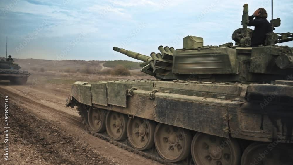 military men ride a tank in the field. military men ride a tank in the field.