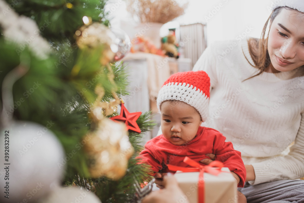 merry christmas and happy Holidays. mother held her daughter near the christmas tree and decorate the christmas tree indoors. the morning before Xmas. Portrait loving family close up. merry christmas and happy Holidays. mother held her daughter near the christmas tree and decorate the christmas tree indoors. the morning before Xmas. Portrait loving family close up.
