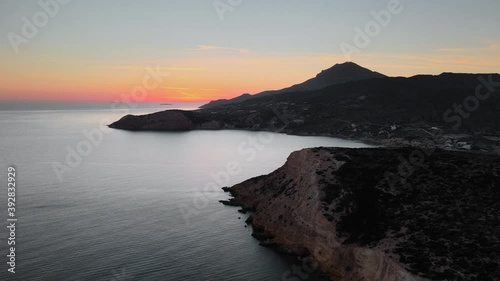 Aerial shot flying over Fyriplaka beach on Milos Island at dusk. Dolly forward photo