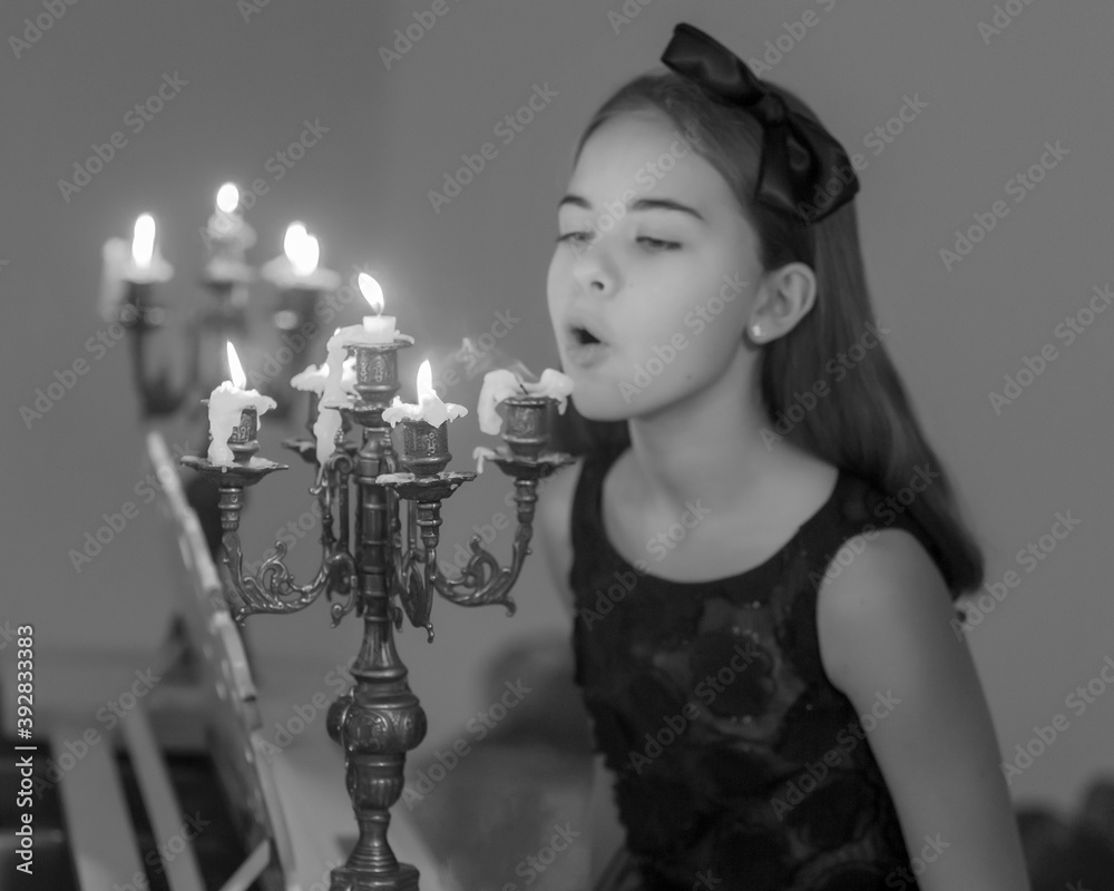 Charming Preteen Girl Blowing out Candles in Vintage Chandelie. Stock