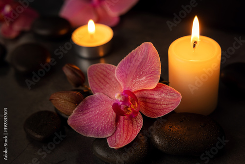 orchid flower with spa stones and candles. beauty treatment concept