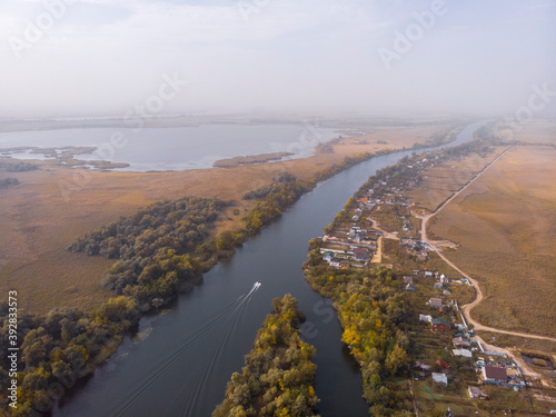 Aerial Shot on Motor Fisherman Boat Floats by Floodplains in Dnieper River near Kherson at Early Autumn photo