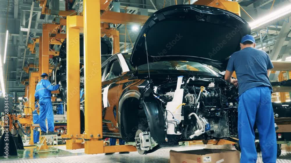 Car mechanic assembling a car at a car manufacturing plant