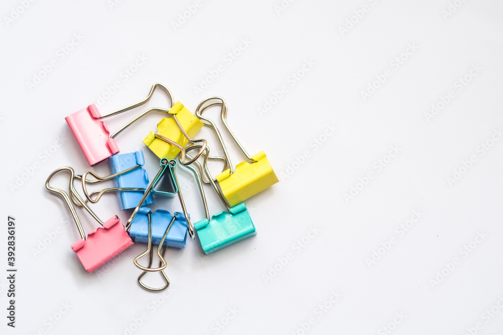 Colored iron paper clips. paper clips with many unique pastel color variants isolated on a white background, Binder clip is a simple device for binding sheets of paper together, metal clips in chaos Colored iron paper clips. paper clips with many unique pastel color variants isolated on a white background, Binder clip is a simple device for binding sheets of paper together, metal clips in chaos
