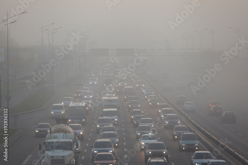 cars driving in the city in the morning mist