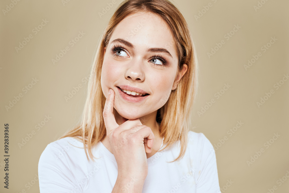 Cheerful blonde gesturing with her hands studio beige background Cheerful blonde gesturing with her hands studio beige background