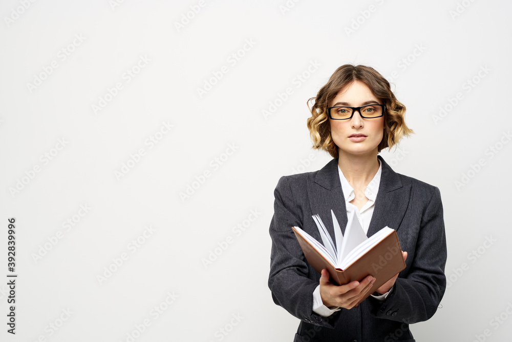 Business woman in a classic suit with a notebook in her hand and glasses on her face Copy Space Business woman in a classic suit with a notebook in her hand and glasses on her face Copy Space