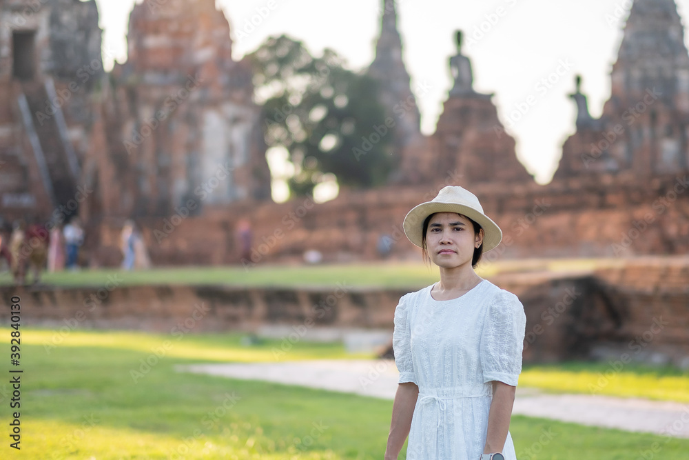 Tourist Woman in white dress visiting to ancient stupa in Wat Chaiwatthanaram temple in Ayutthaya Historical Park, summer, Asia and Thailand travel concept