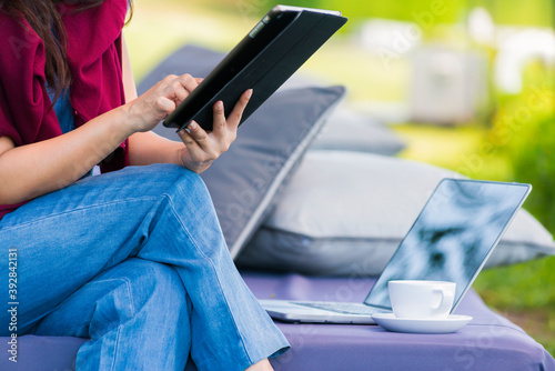 Advertising,Time to relax, Holiday, Technology, Education Concept - Distance education. Cropped image of Woman showing tablet a blank screen and typing on laptop computer.