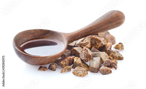 Propolis tincture in wooden spoon on white background. Natural antibiotic photo