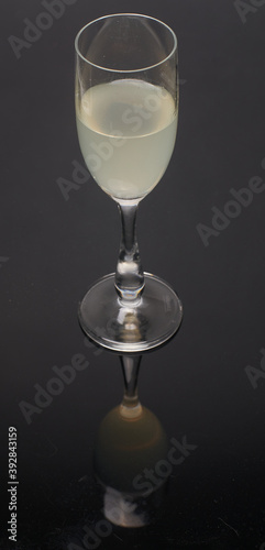 glas with citron juice reflection on dark ground
