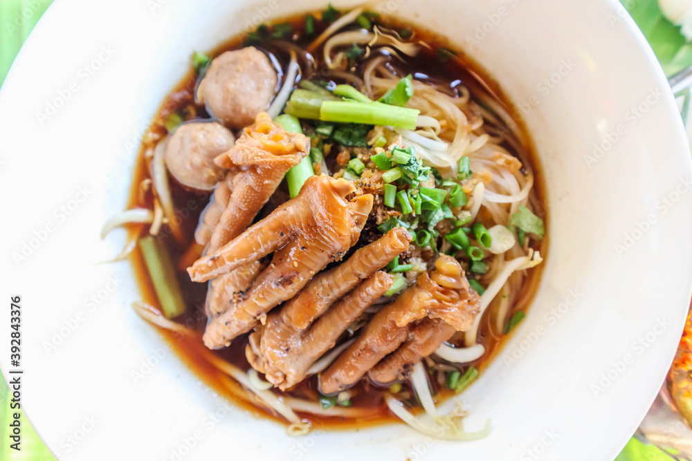 Delicious chicken feet noodles in a white plate with vegetables Delicious chicken feet noodles in a white plate with vegetables
