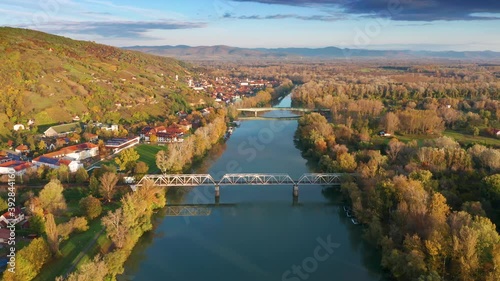 Tokaj, Hungary - 4K flying above River Tisza at the town of Tokaj on a warm, sunny autumn morning with blue sky and golden vineyards photo