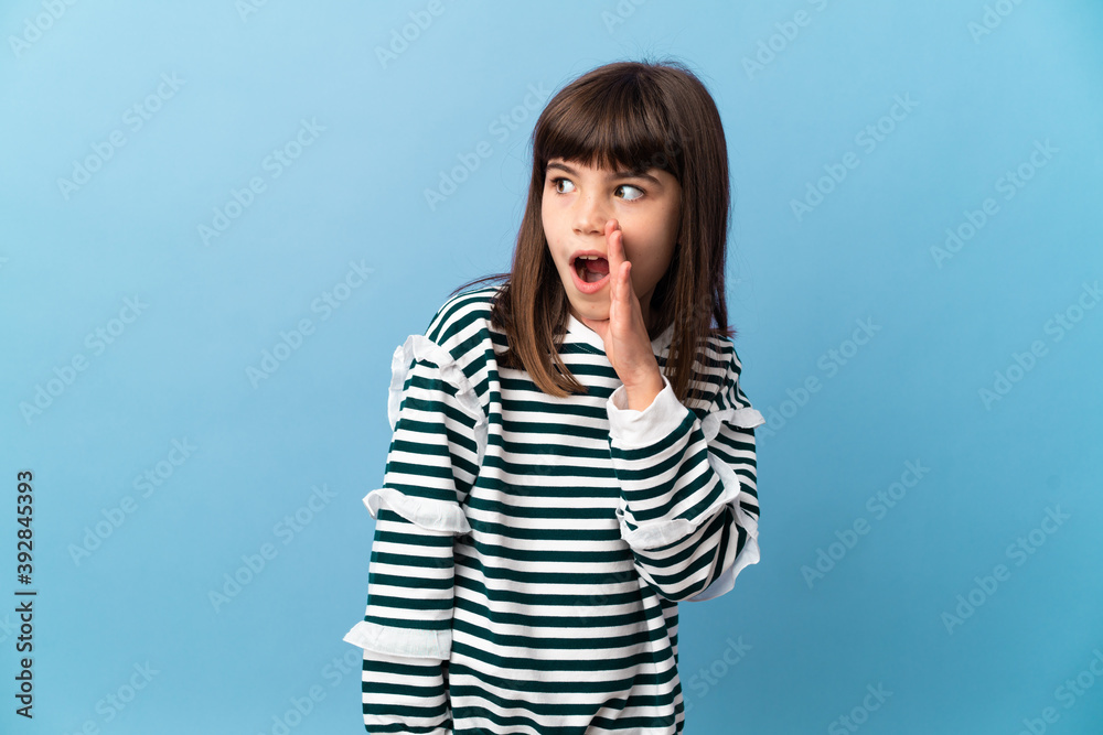 Little girl over isolated background whispering something with surprise gesture while looking to the side Little girl over isolated background whispering something with surprise gesture while looking to the side
