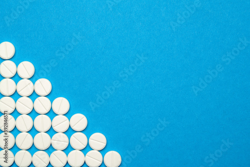 group of round white pills on blue background