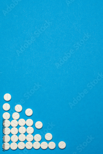 group of round white pills on blue background