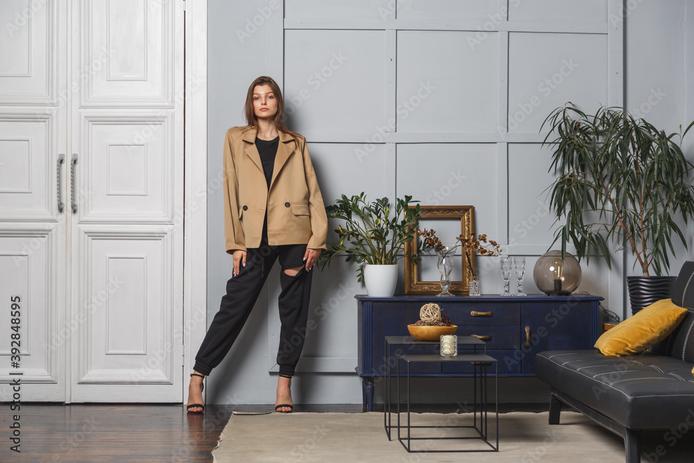 Young brunette woman with long hair wearing a stylish fashionable jacket and black pants Young brunette woman with long hair wearing a stylish fashionable jacket and black pants