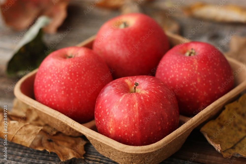 Juicy red apples and autumn leaves on the table Juicy red apples and autumn leaves on the table