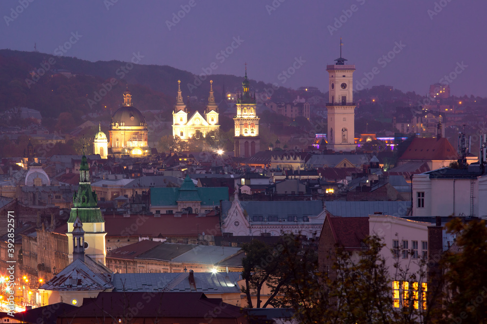 Aerial night panoramic view of churches, city hall and houses roofs in historical old city of Lviv, Ukraine.
