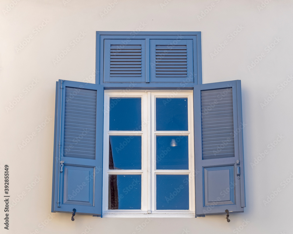 Fototapeta premium vintage blue shutters with white frame window, Athens Greece