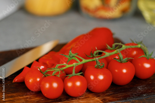 Wooden cutting board with cherry tomatoes and pepper on kitchen counter